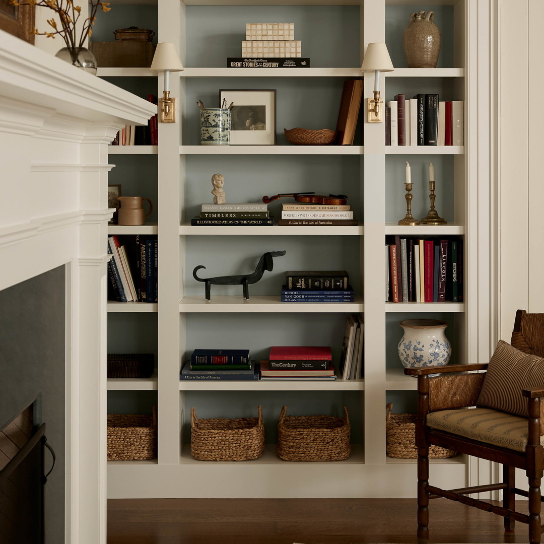 a living room filled with lots of books and furniture