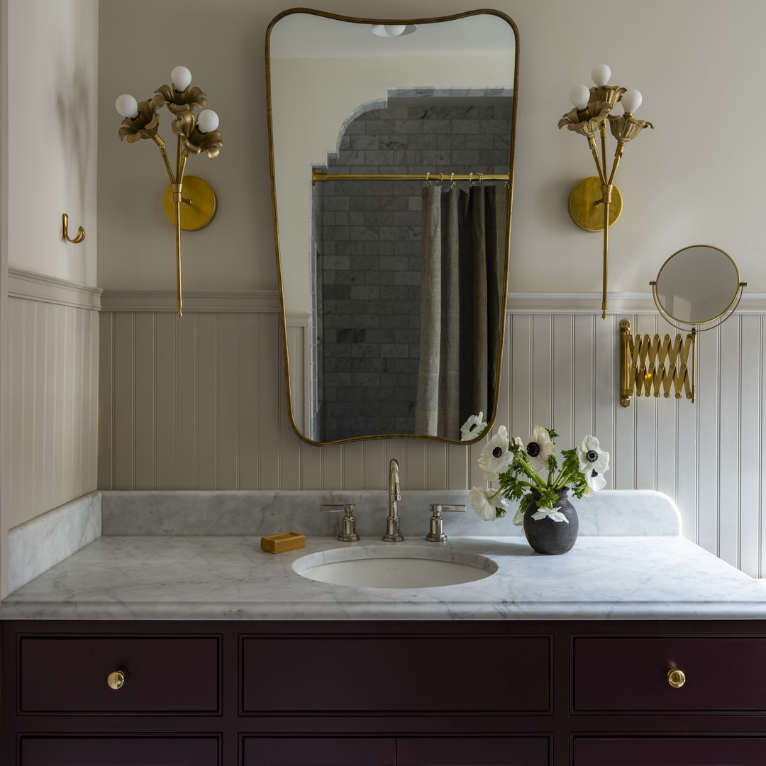 a bathroom with a marble counter top and purple cabinets