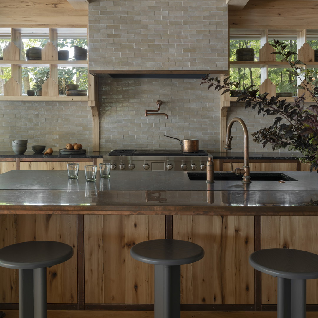 a kitchen with a stove top oven sitting next to two stools