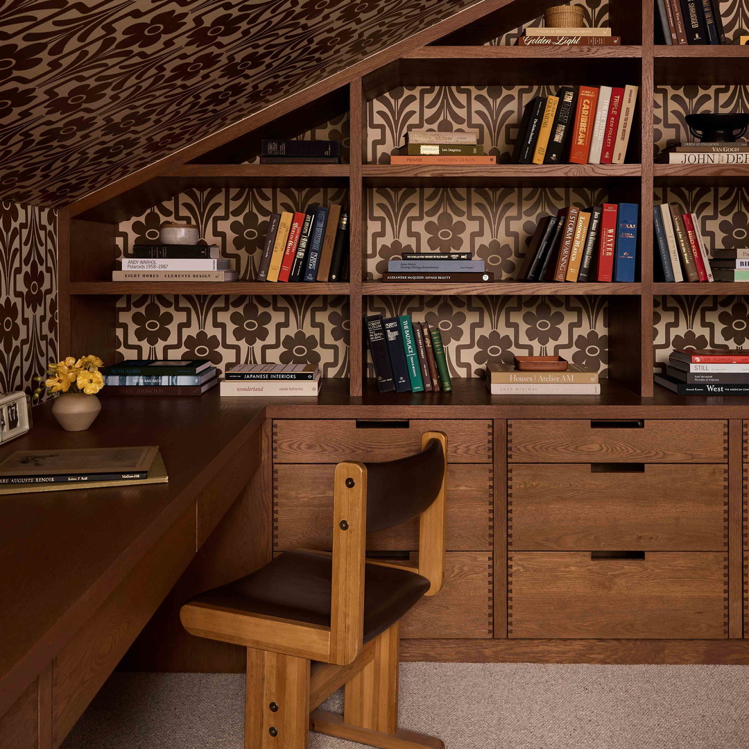 a room with a desk, bookshelf and a chair