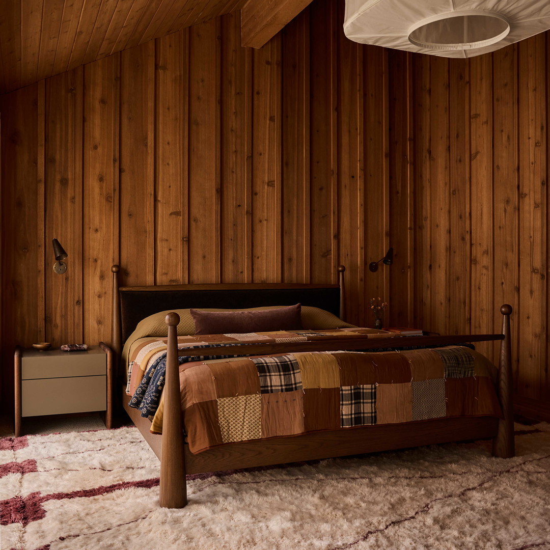 a bedroom with wood paneling and a bed