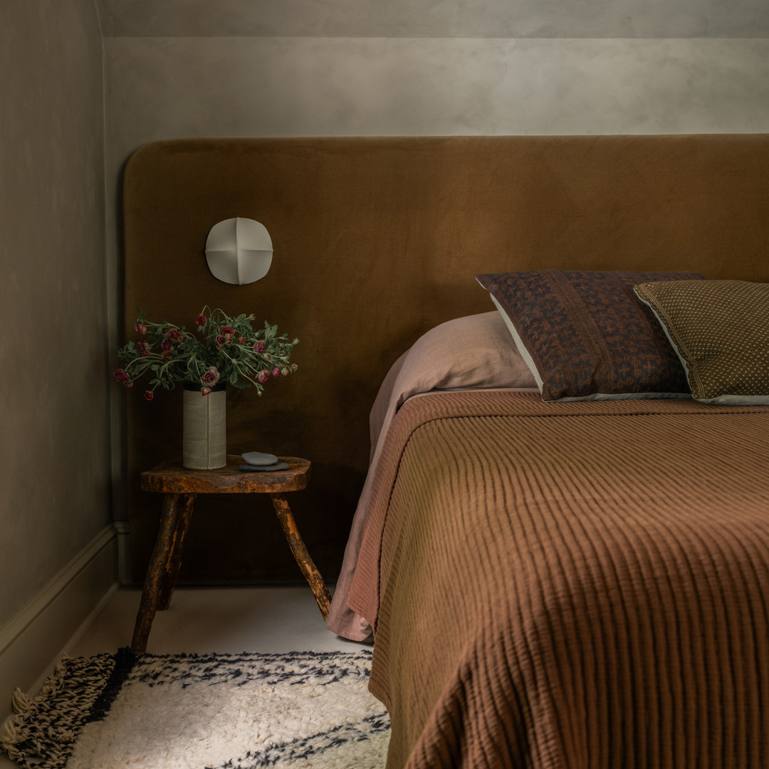 a bed with a brown headboard and a brown blanket