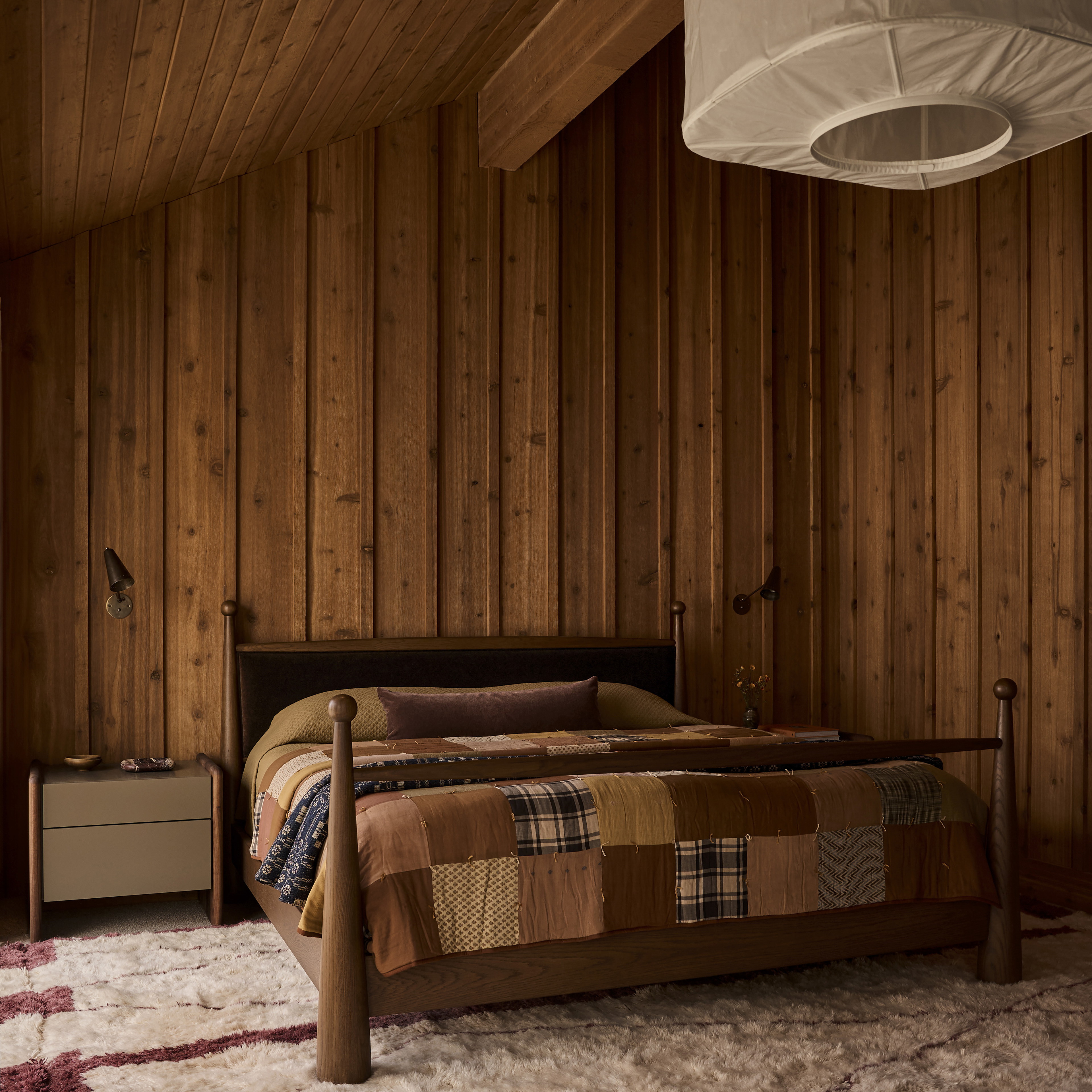 a bedroom with wood paneling and a bed