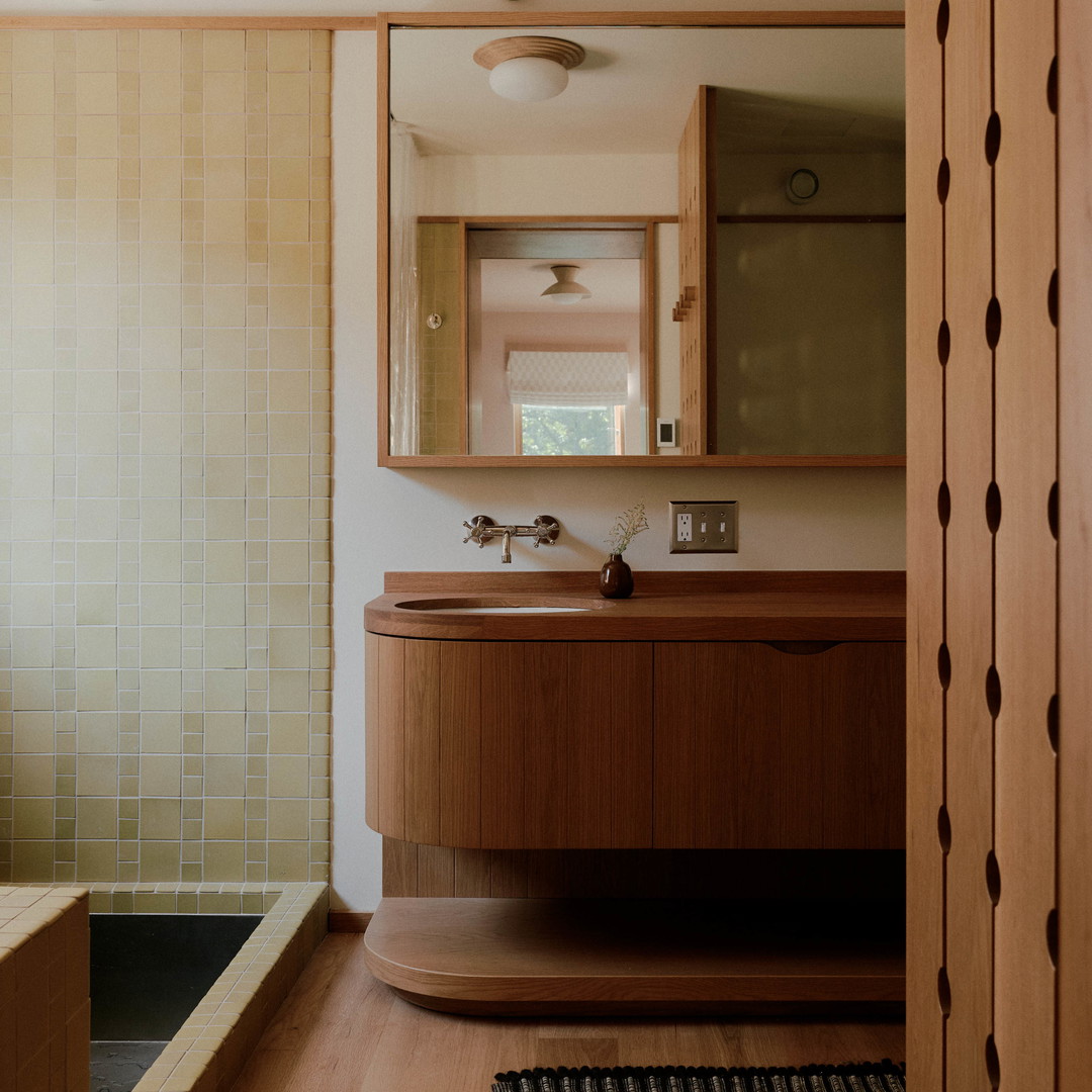 a bathroom with a tub, sink, and mirror