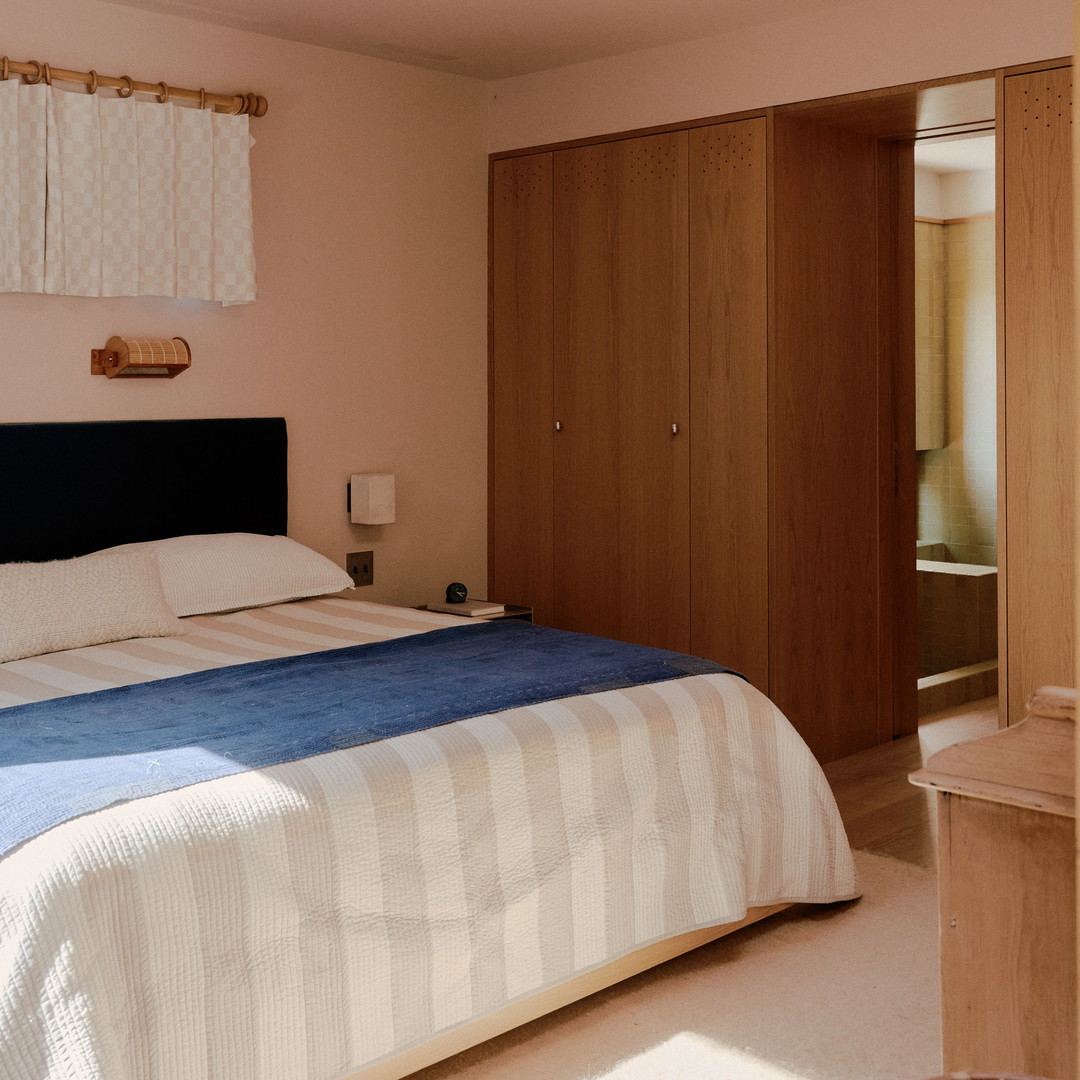 a bedroom with a bed, dresser, and mirror