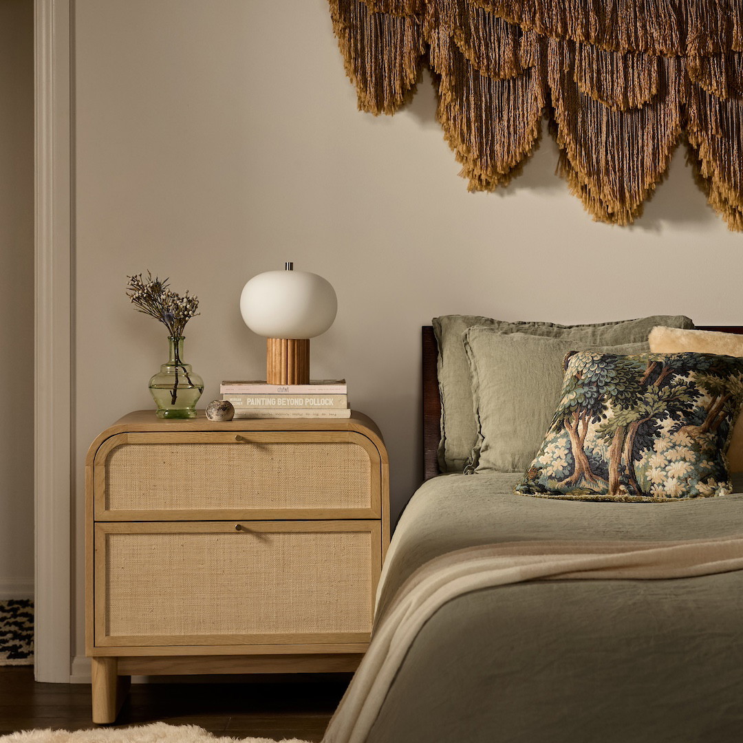 a bed room with a neatly made bed and a night stand