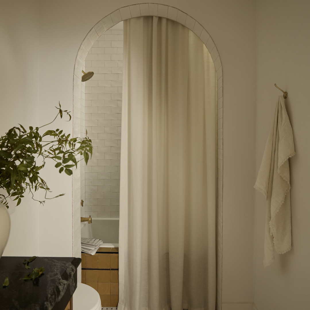 a bathroom with a white shower curtain and a black counter