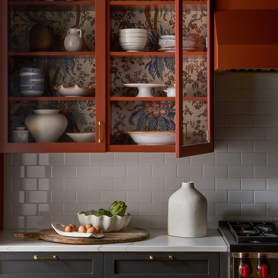 a kitchen with red cabinets and white counter tops