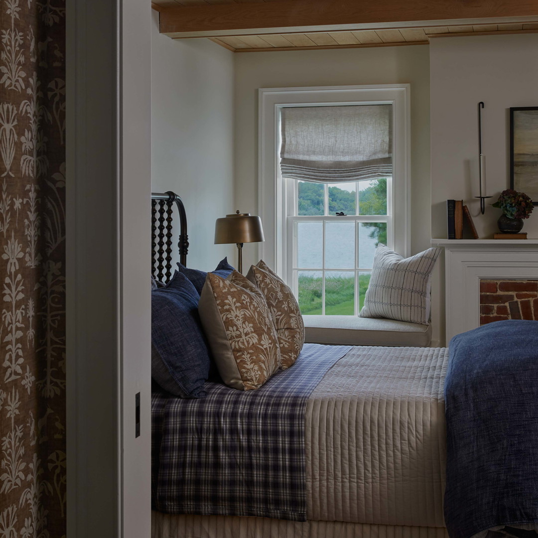 a bed sitting in a bedroom next to a window