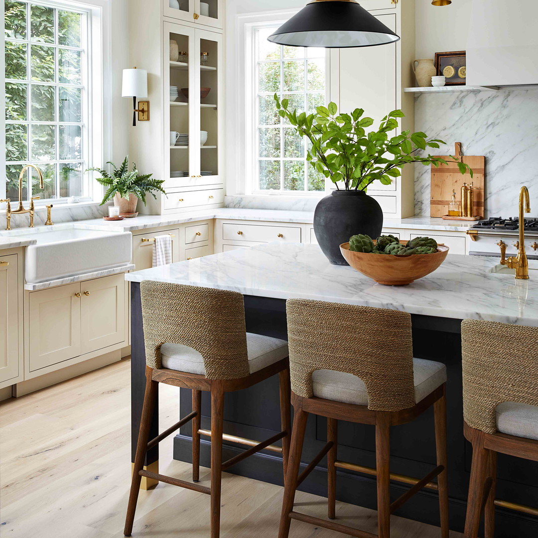 a kitchen with a marble counter top and wooden chairs