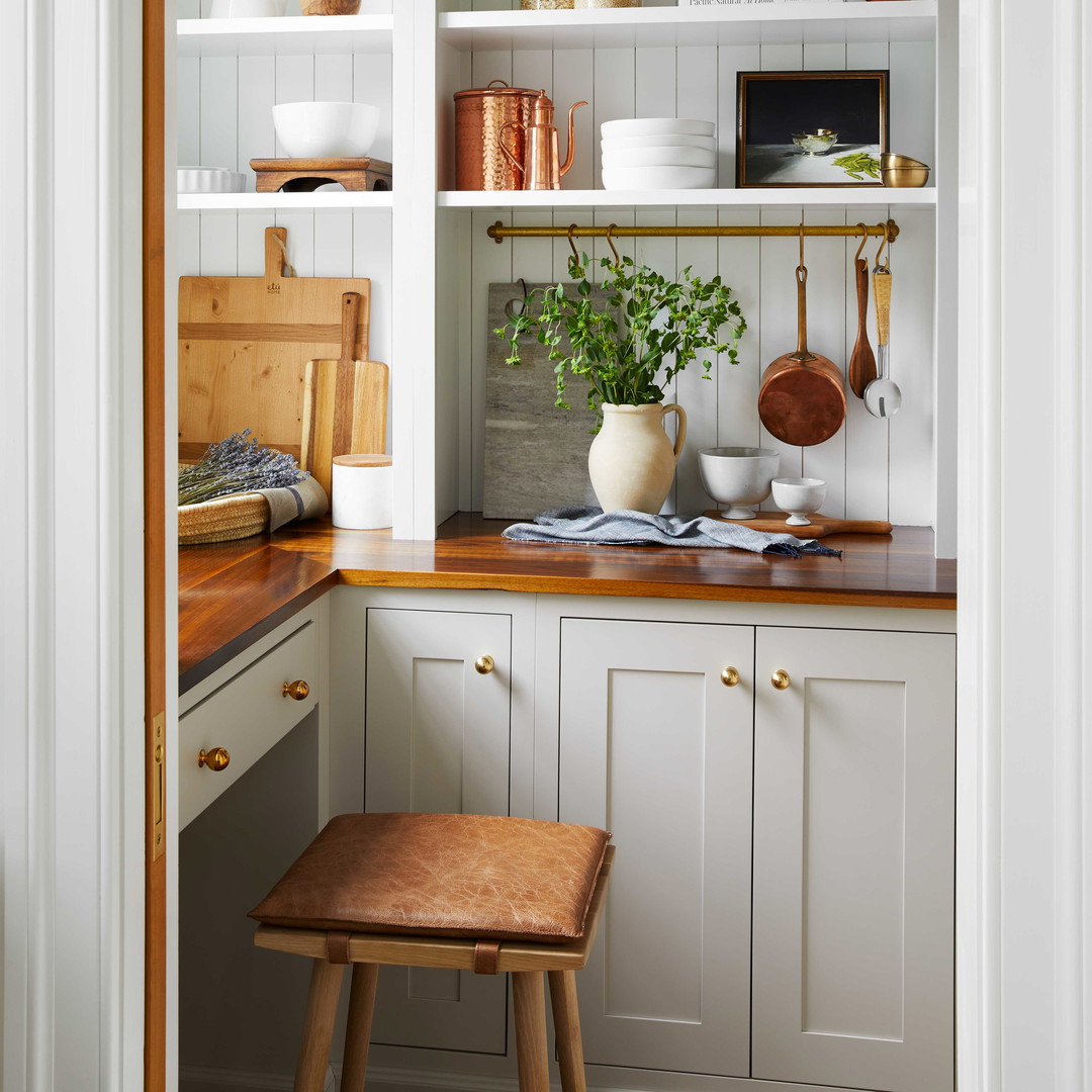 a kitchen with white cabinets and a wooden stool