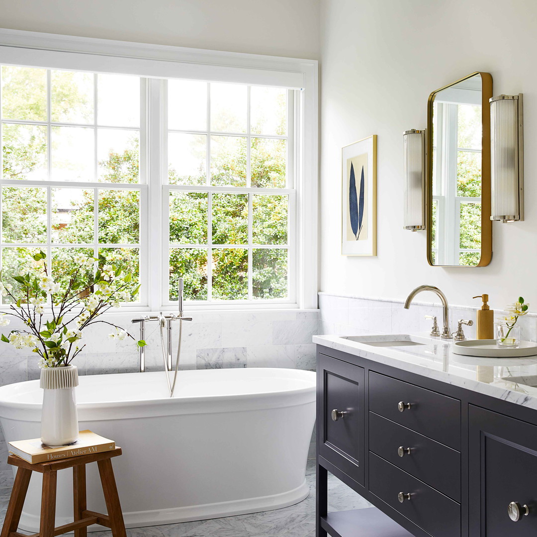 a bathroom with two sinks, a tub and a window