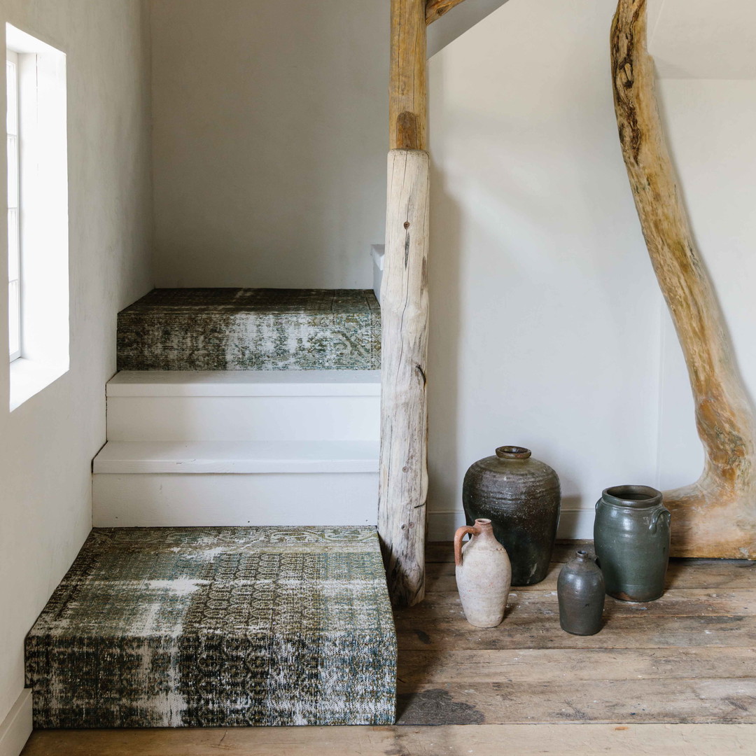 a room with a bed and some vases on the floor