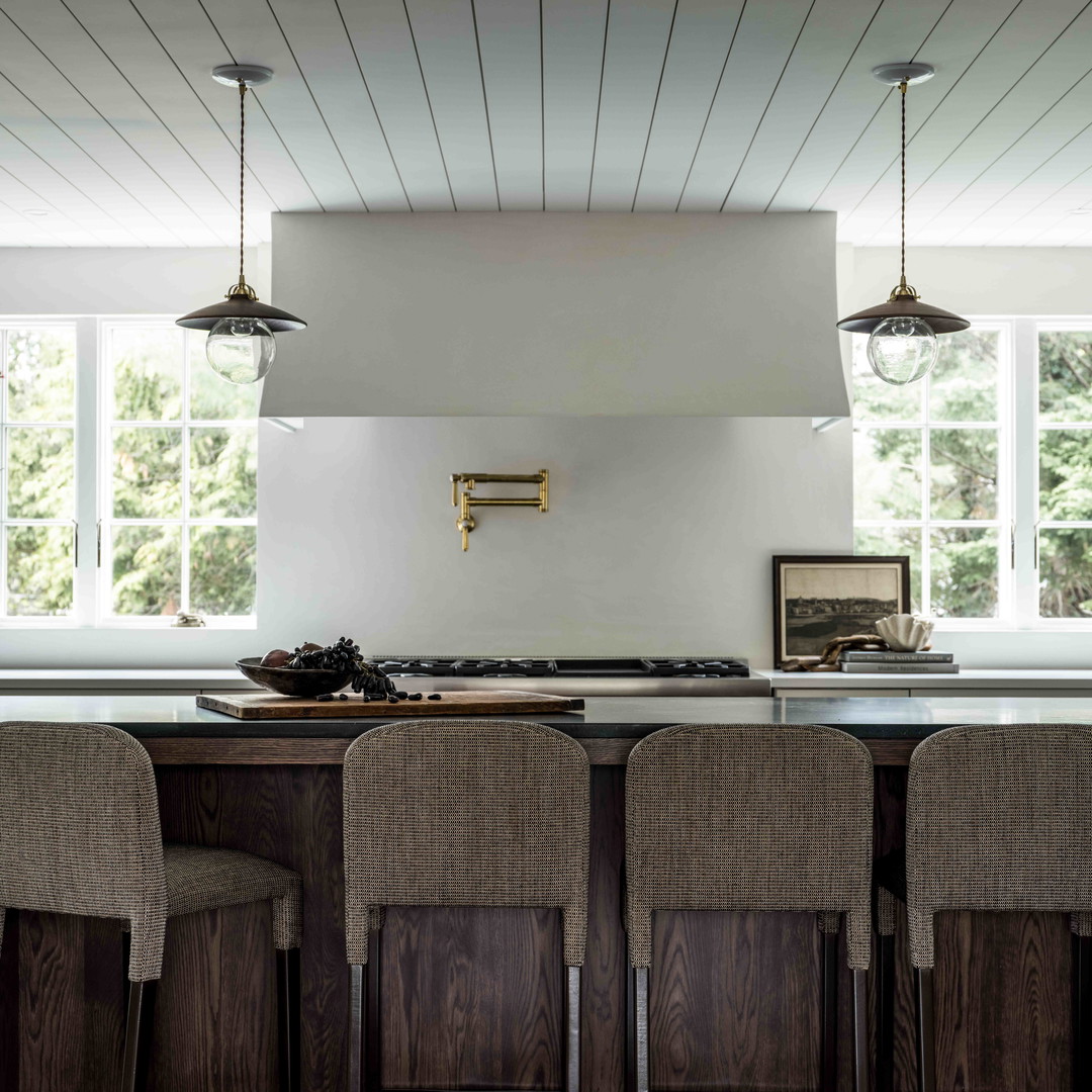 a kitchen with a stove top oven and chairs