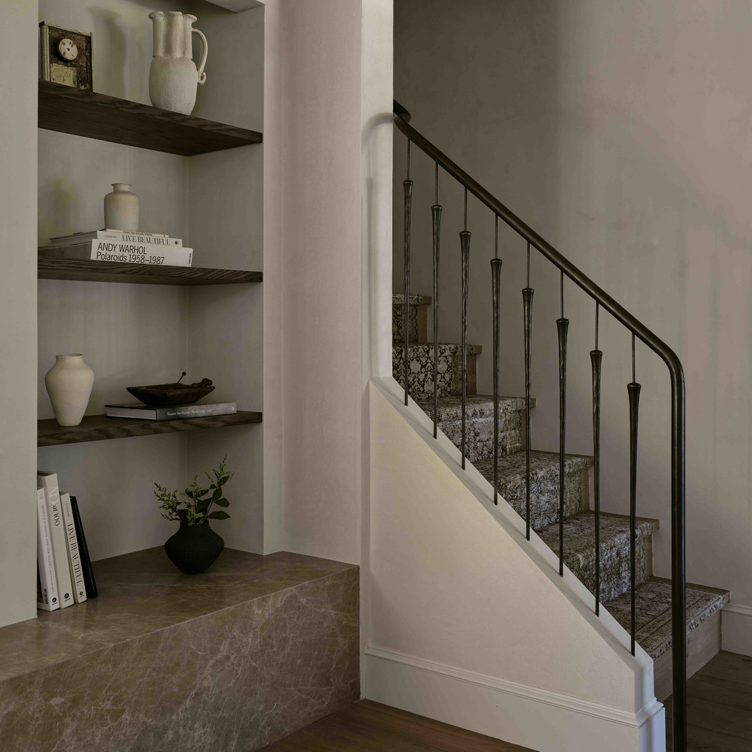 a staircase leading to a living room with bookshelves