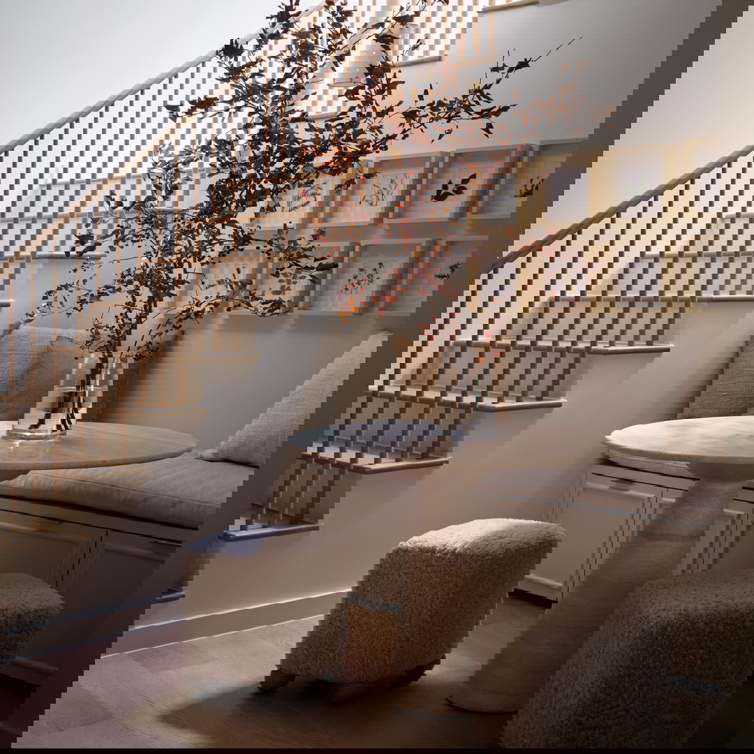 a living room with a table a chair and a stair case