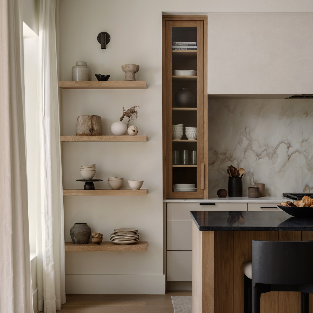 a kitchen with a counter, shelves, and chairs