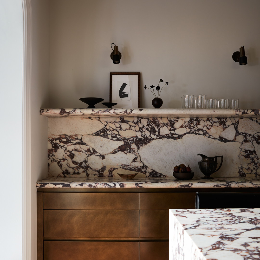 a kitchen with a marble counter top next to a wooden cabinet