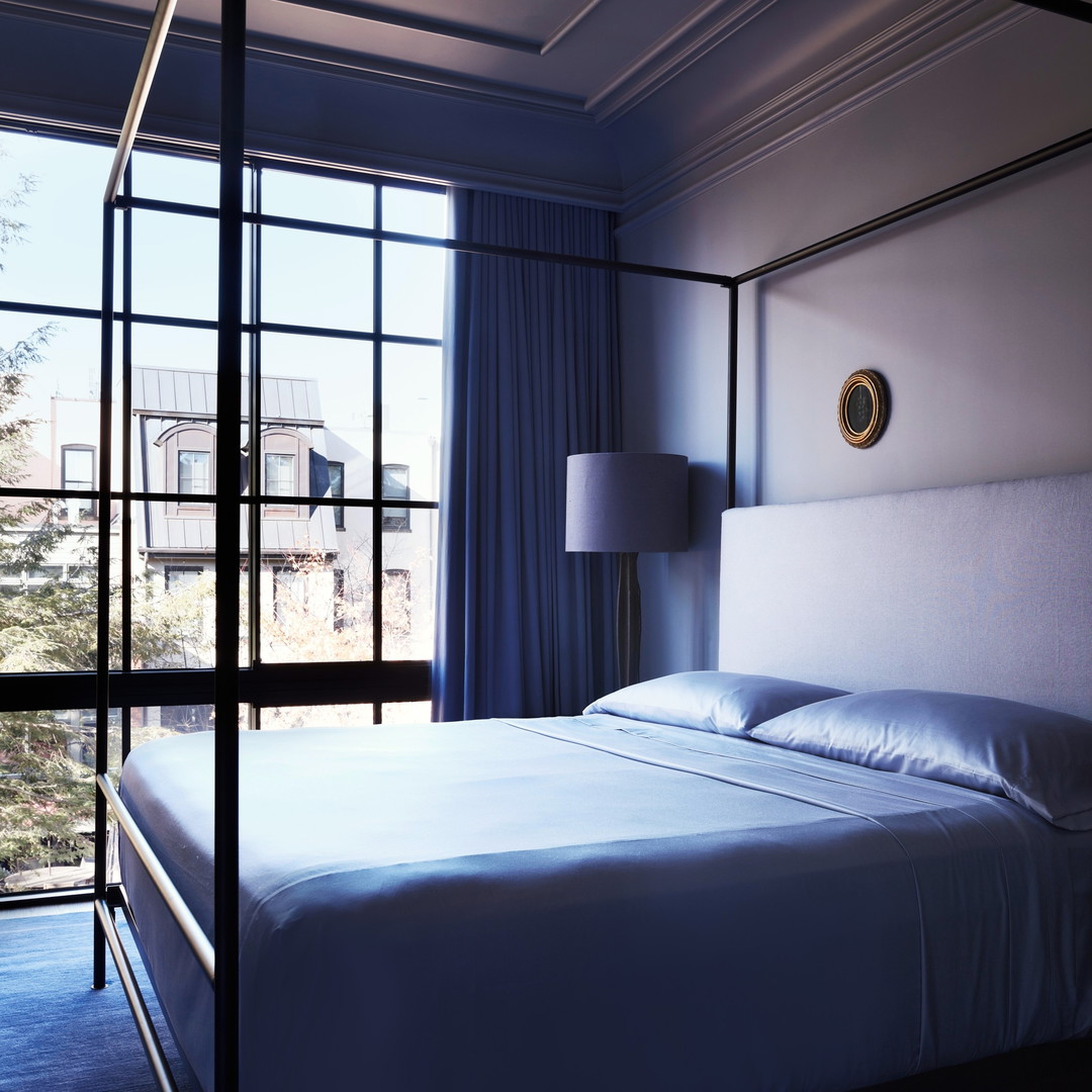 a bedroom with a four poster bed and a large window