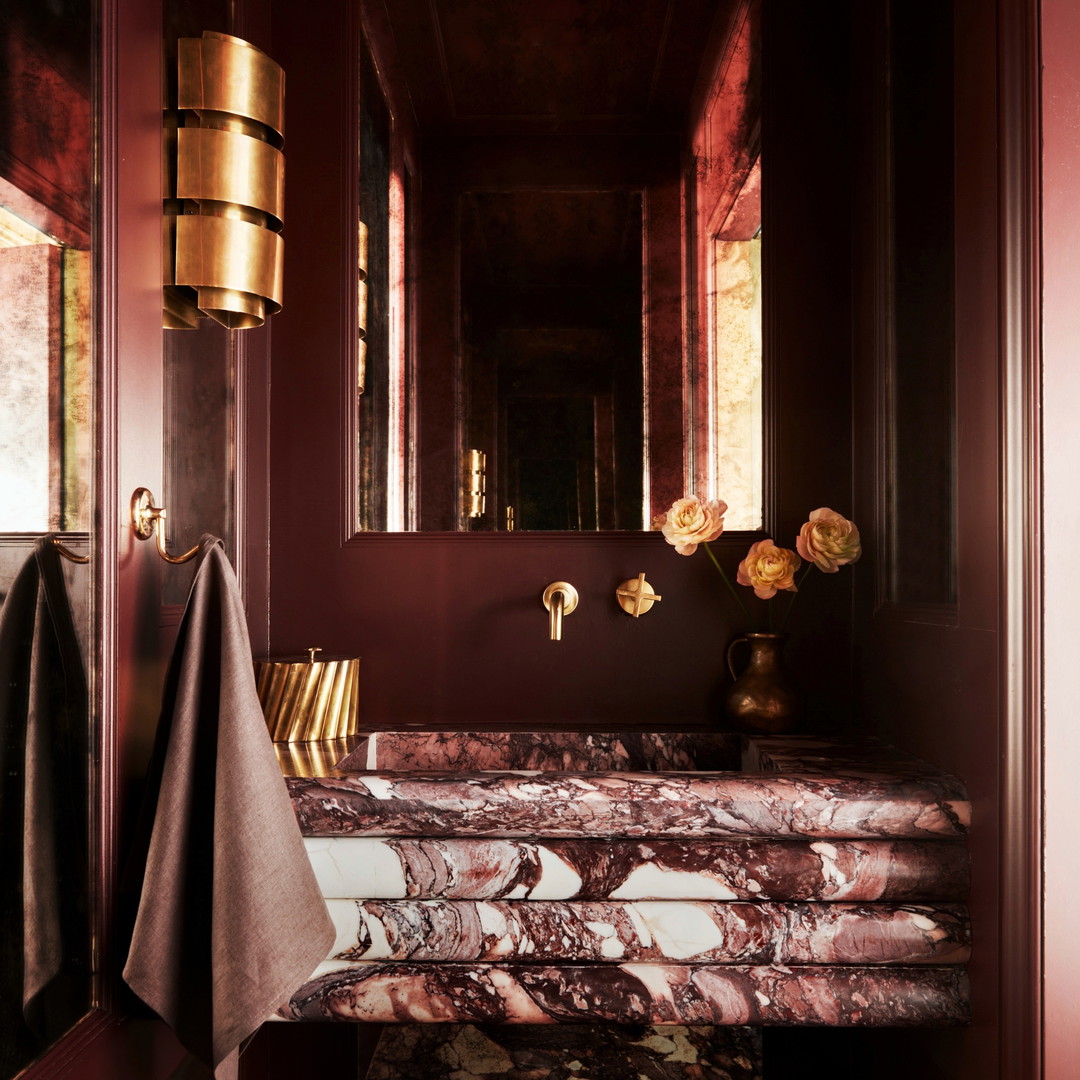 a bathroom with a marble sink and red walls