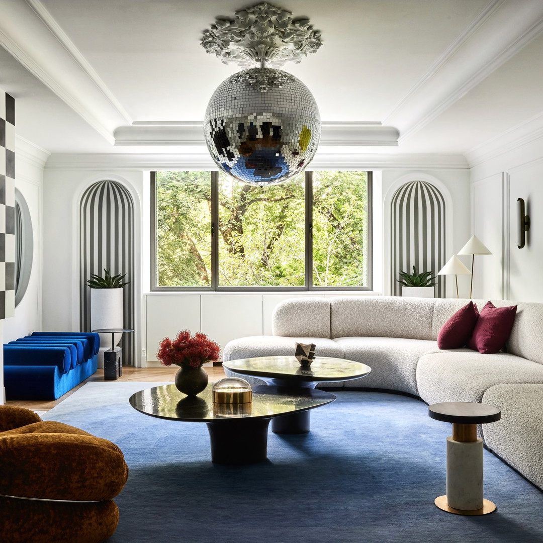 a living room filled with furniture and a disco ball hanging from the ceiling