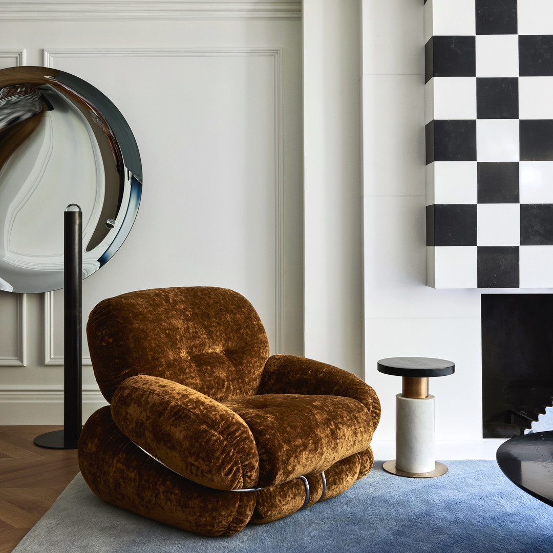 a brown chair sitting on top of a blue rug