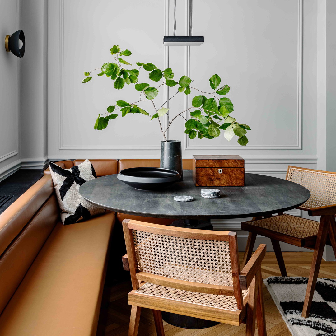 a dining room table with a plant in a vase