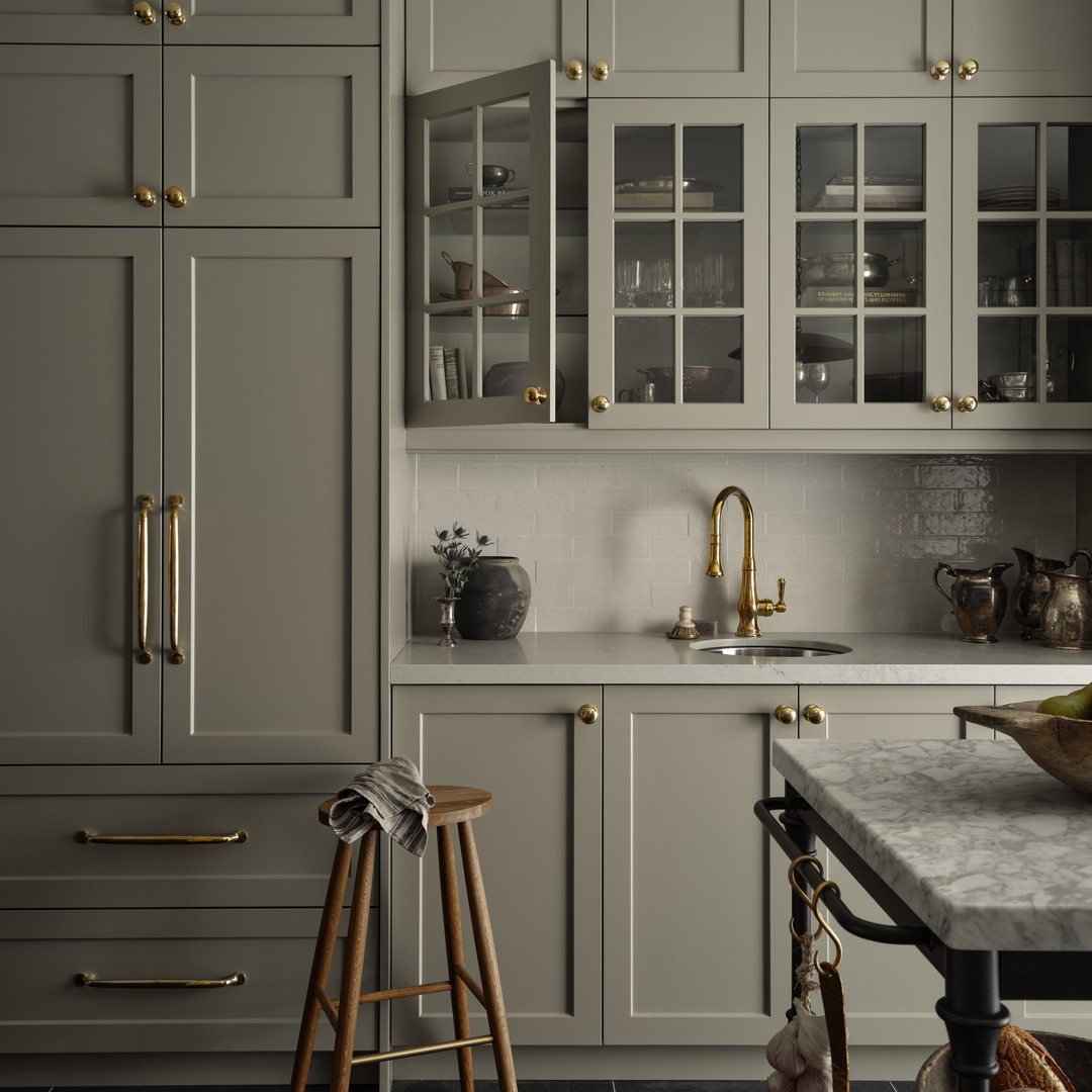 a kitchen with gray cabinets and marble counter tops