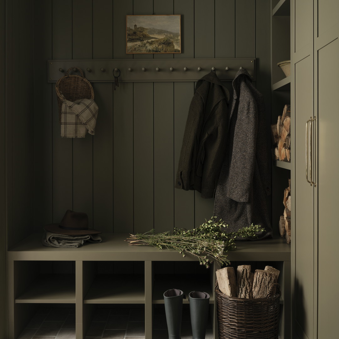 a mud room with a bench, coat rack, and boots