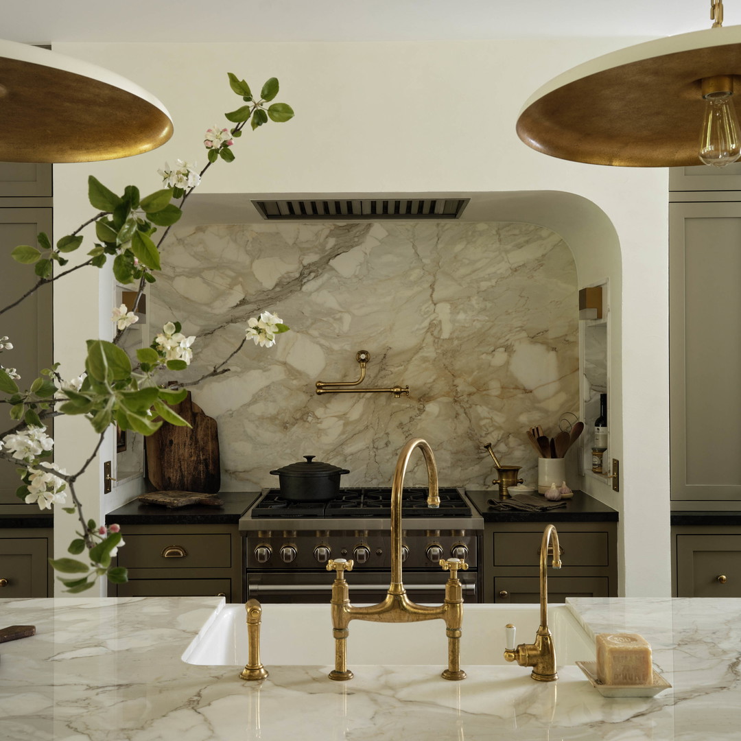 a kitchen with marble counter tops and gold faucets