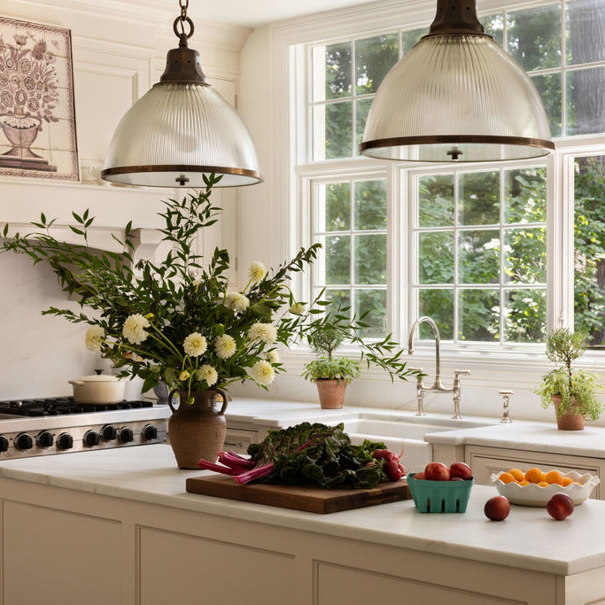 a kitchen with two hanging lights over the island