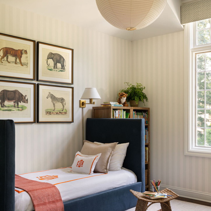 a bedroom with a bed, rug and pictures on the wall