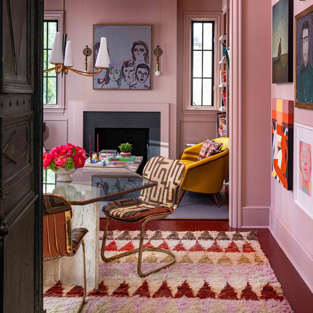 a living room with pink walls and a fireplace