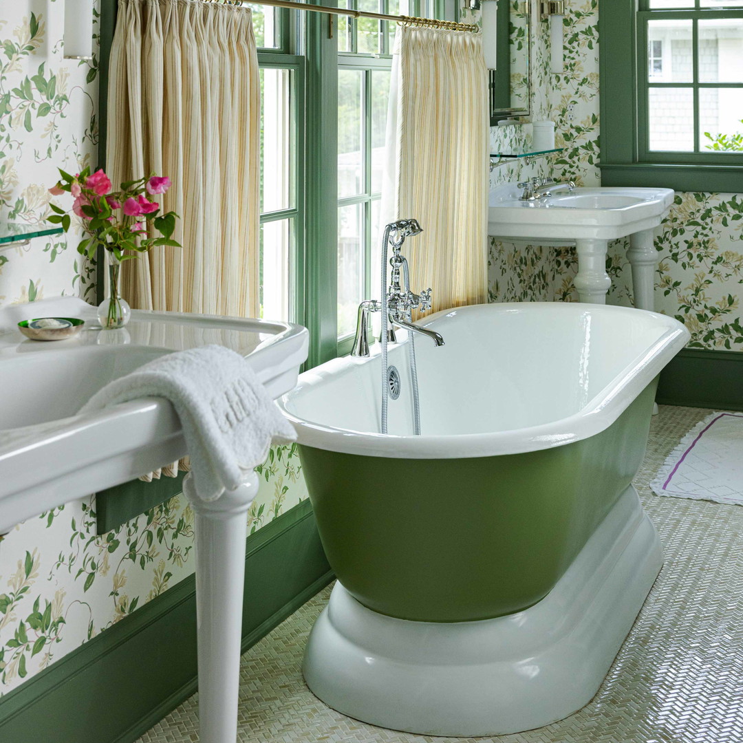 a green and white bathroom with a claw foot tub