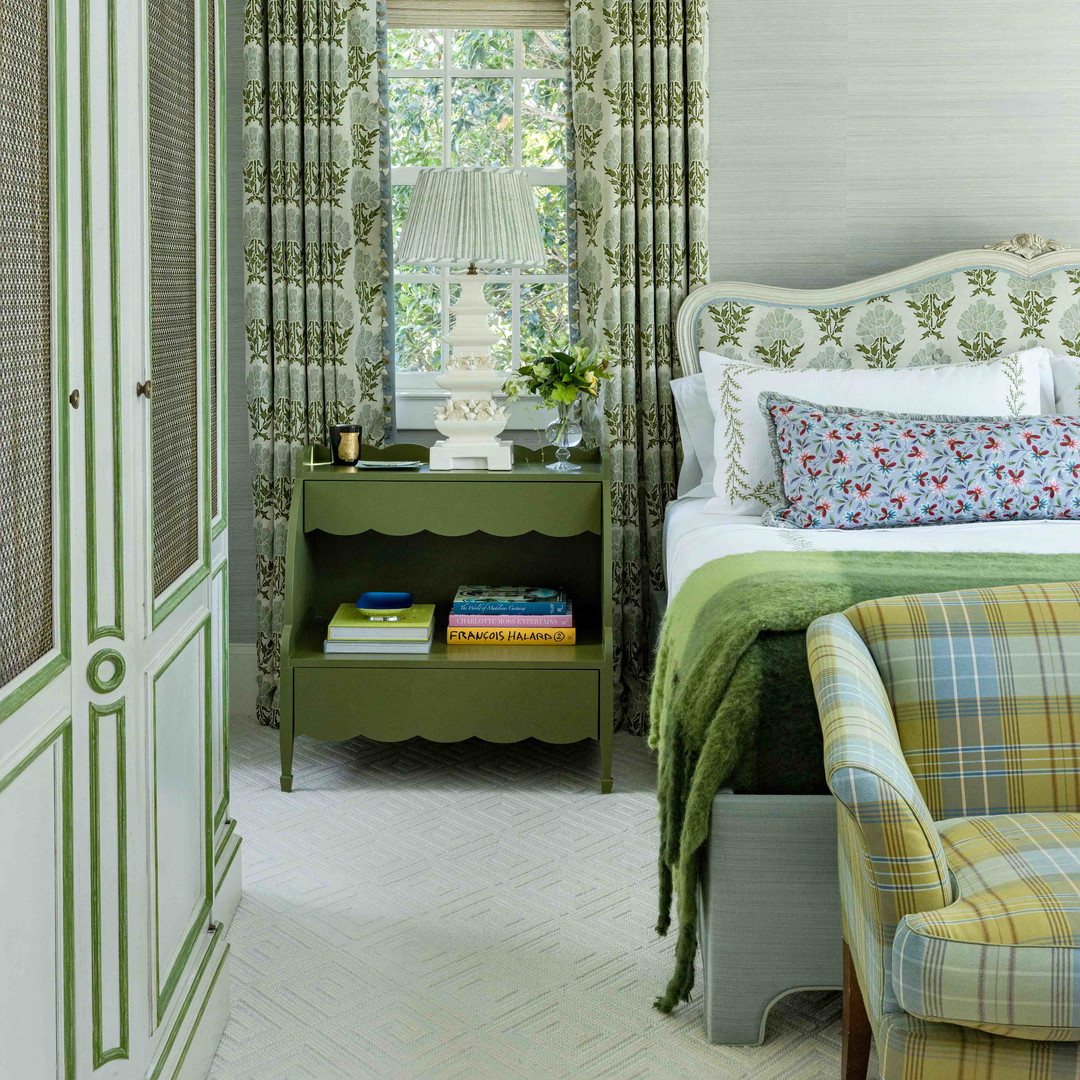 a bed room with a neatly made bed and a chair