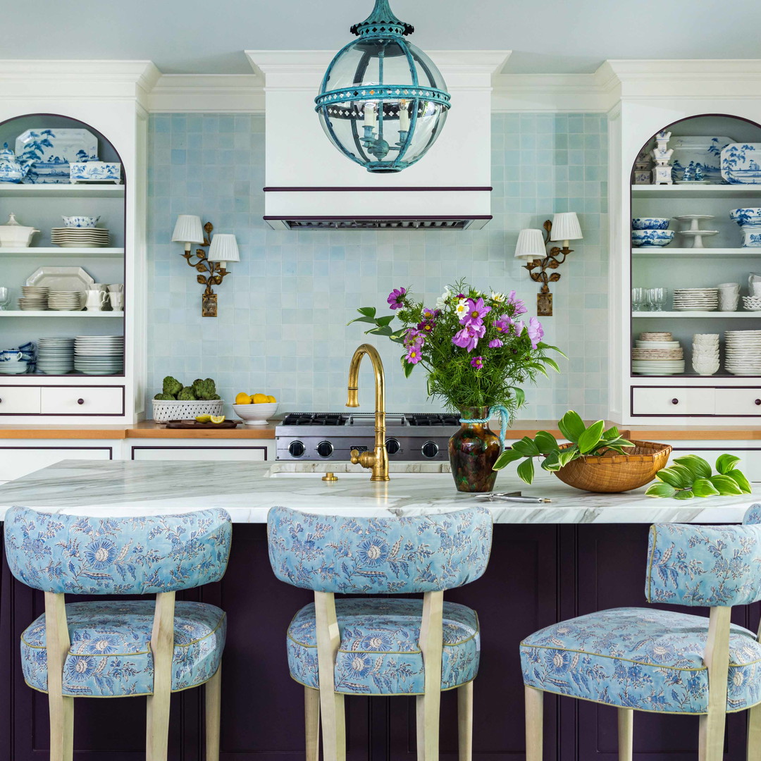 a kitchen with a center island and blue chairs