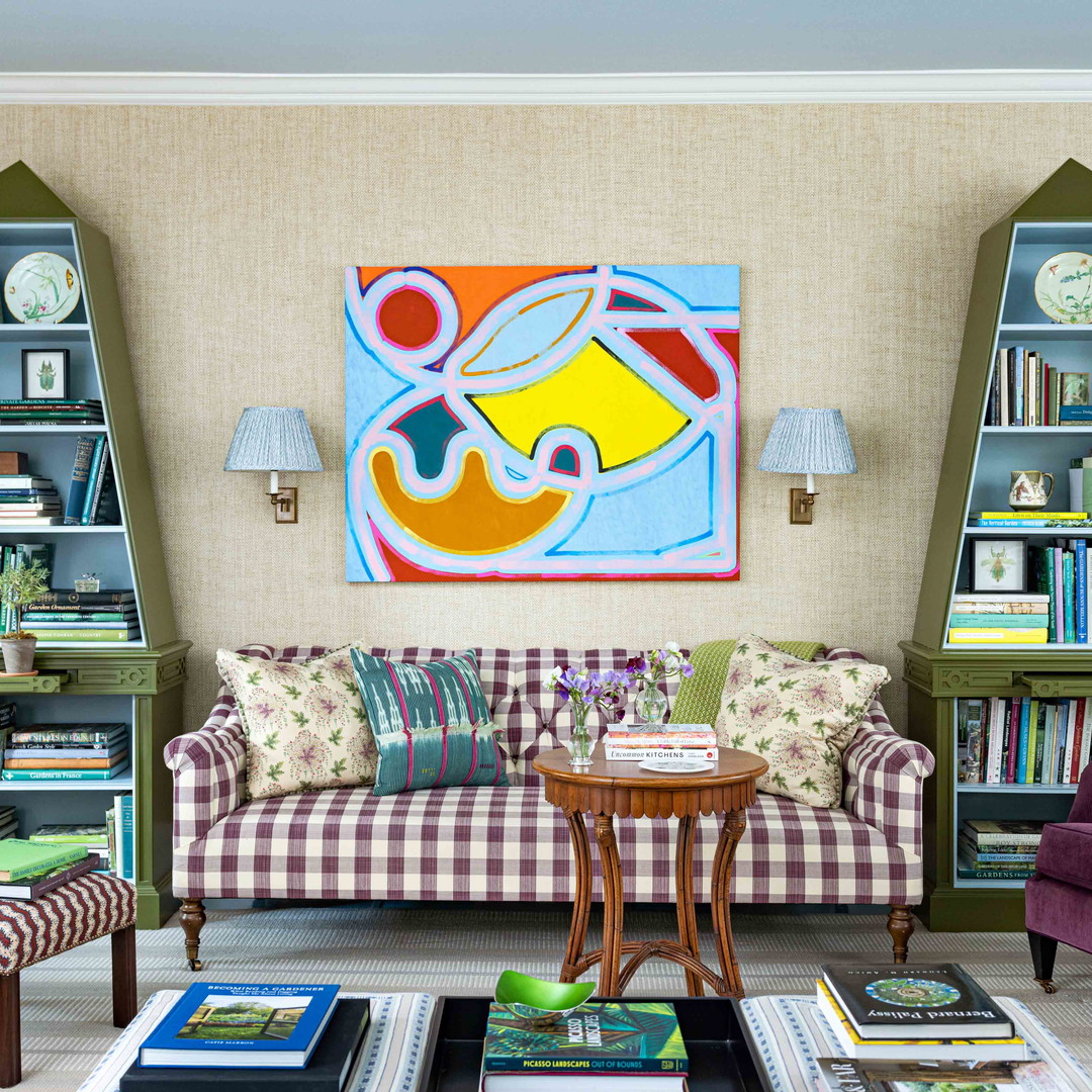 a living room filled with furniture and a painting on the wall