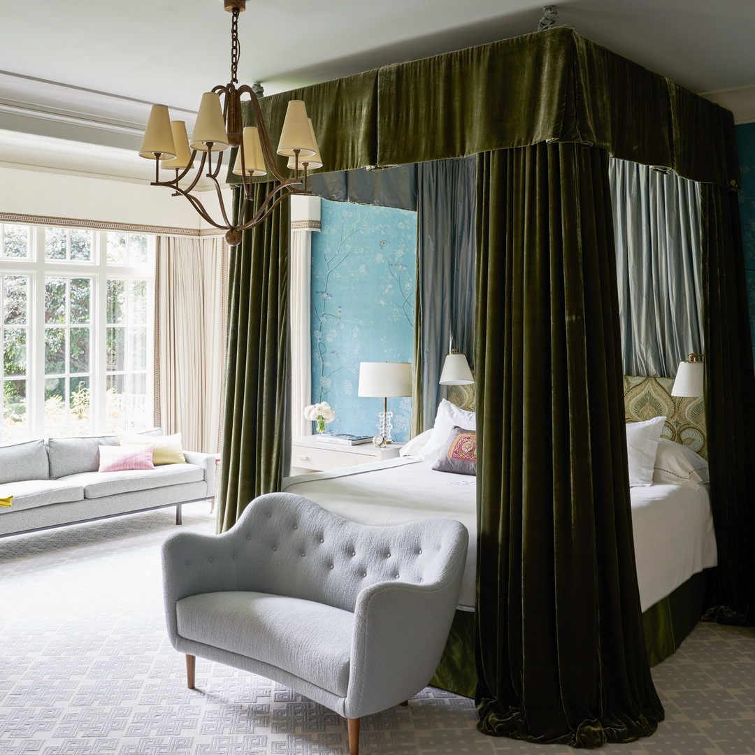 a bedroom with a four poster bed and a chandelier