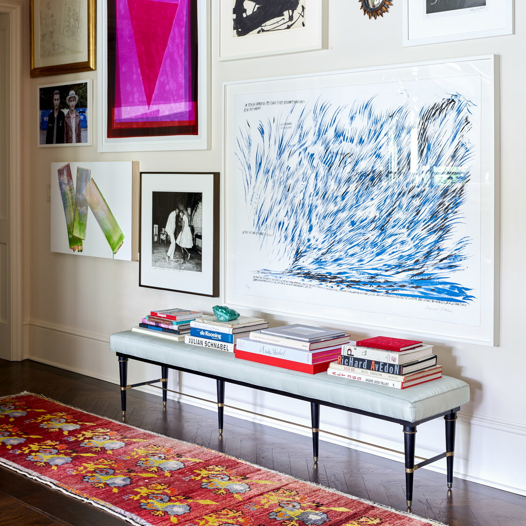 a room with a bench and a bunch of pictures on the wall