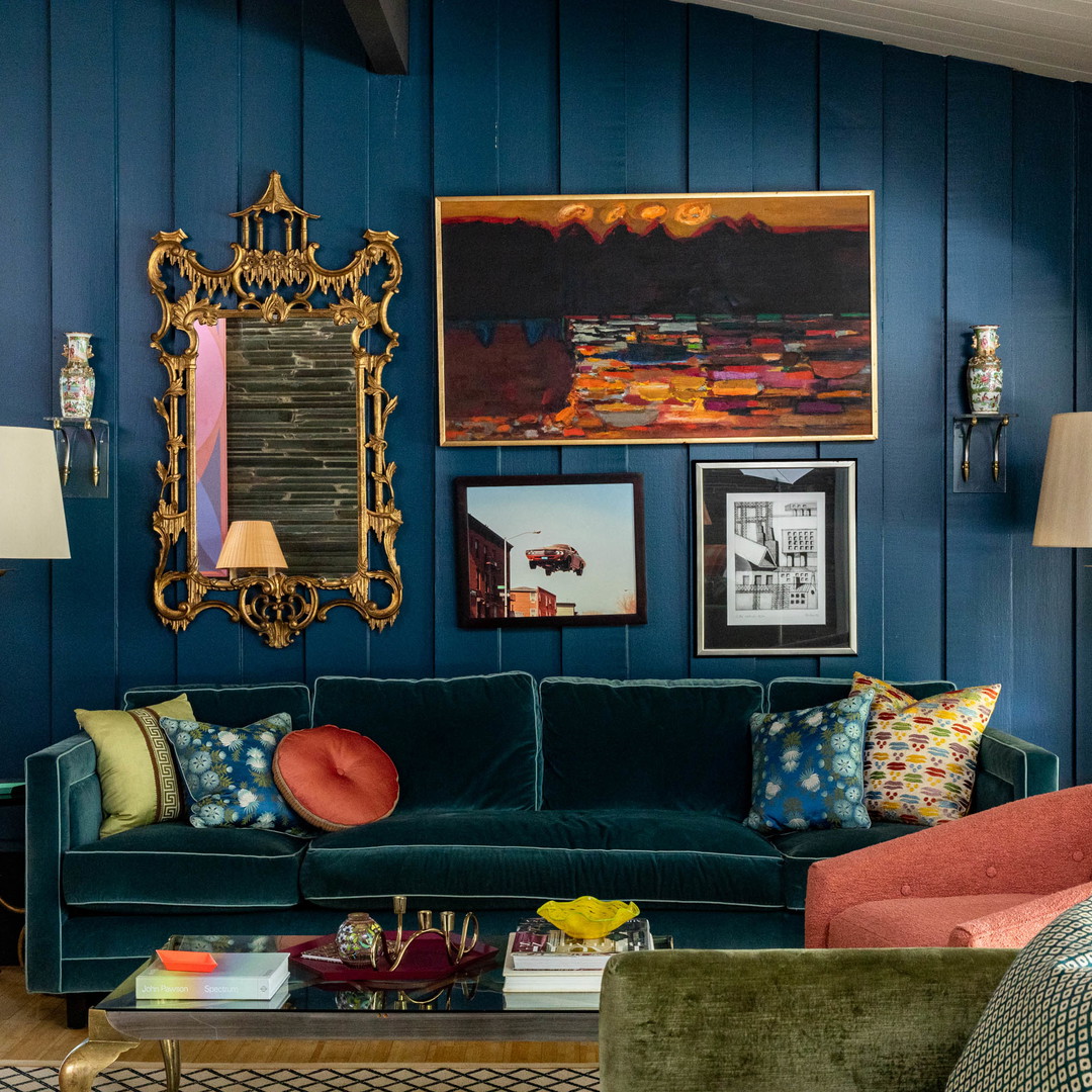 a living room filled with furniture and a painting on the wall