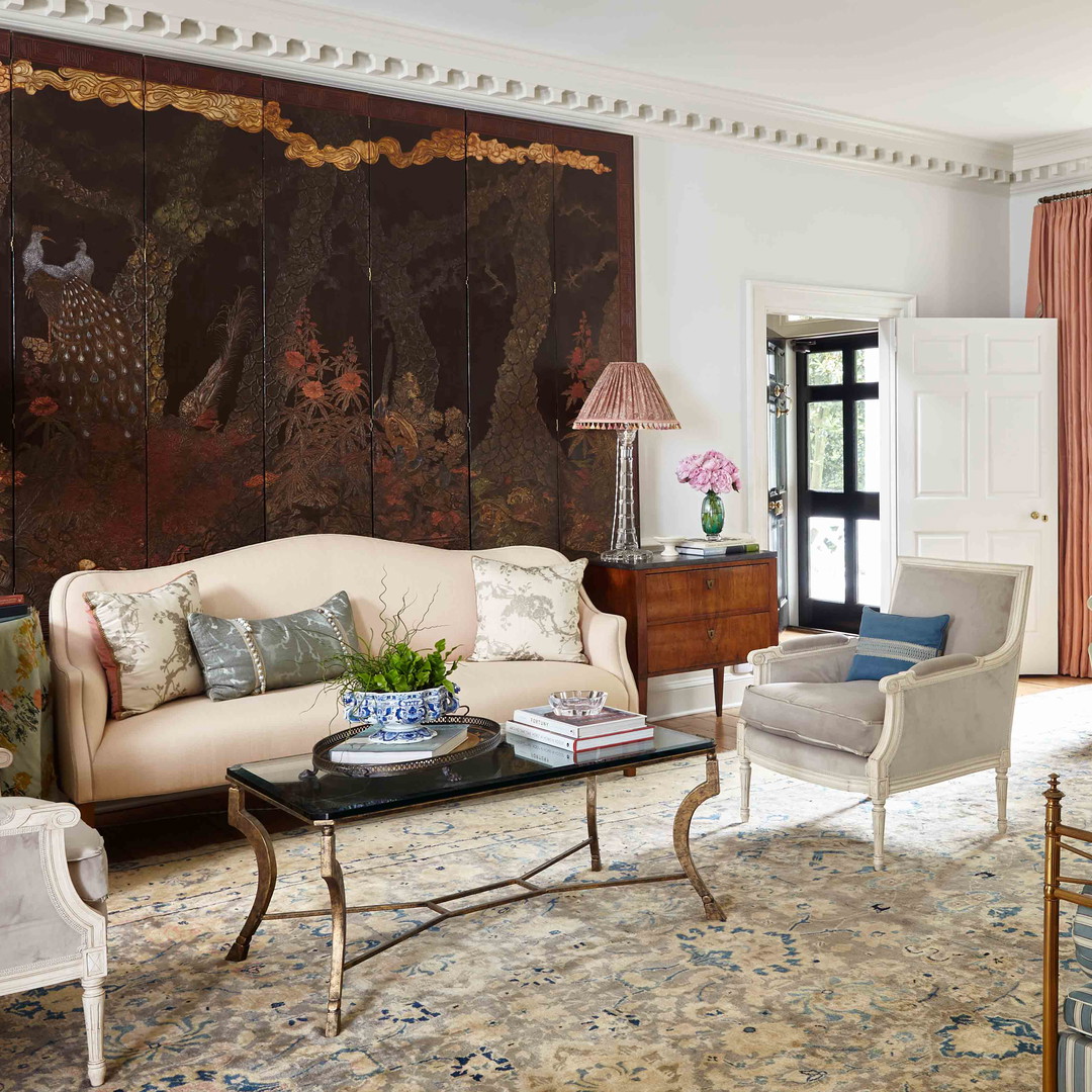 a living room filled with furniture and a painting on the wall