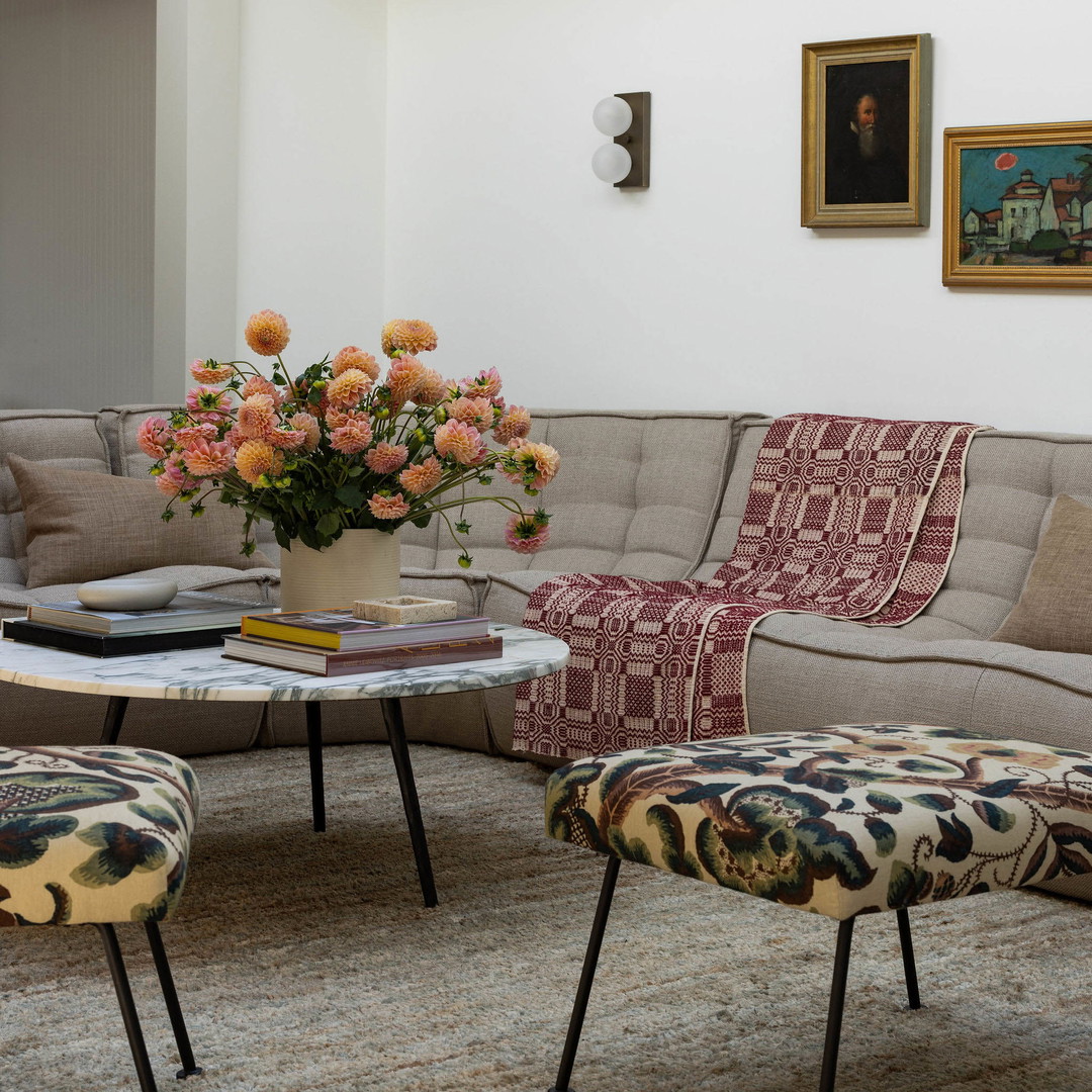 a living room filled with furniture and a vase of flowers