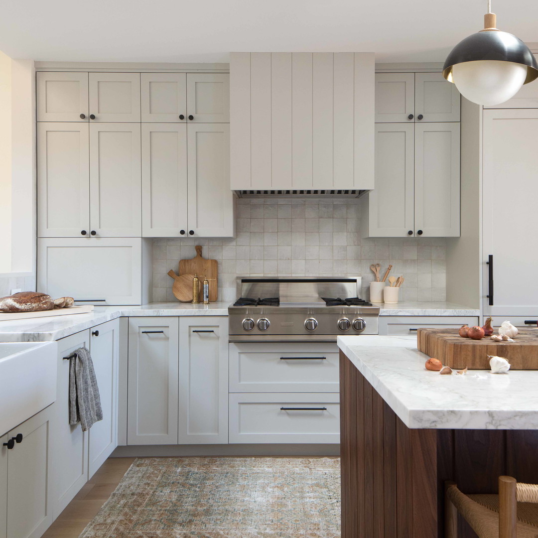 a kitchen with white cabinets and wooden floors