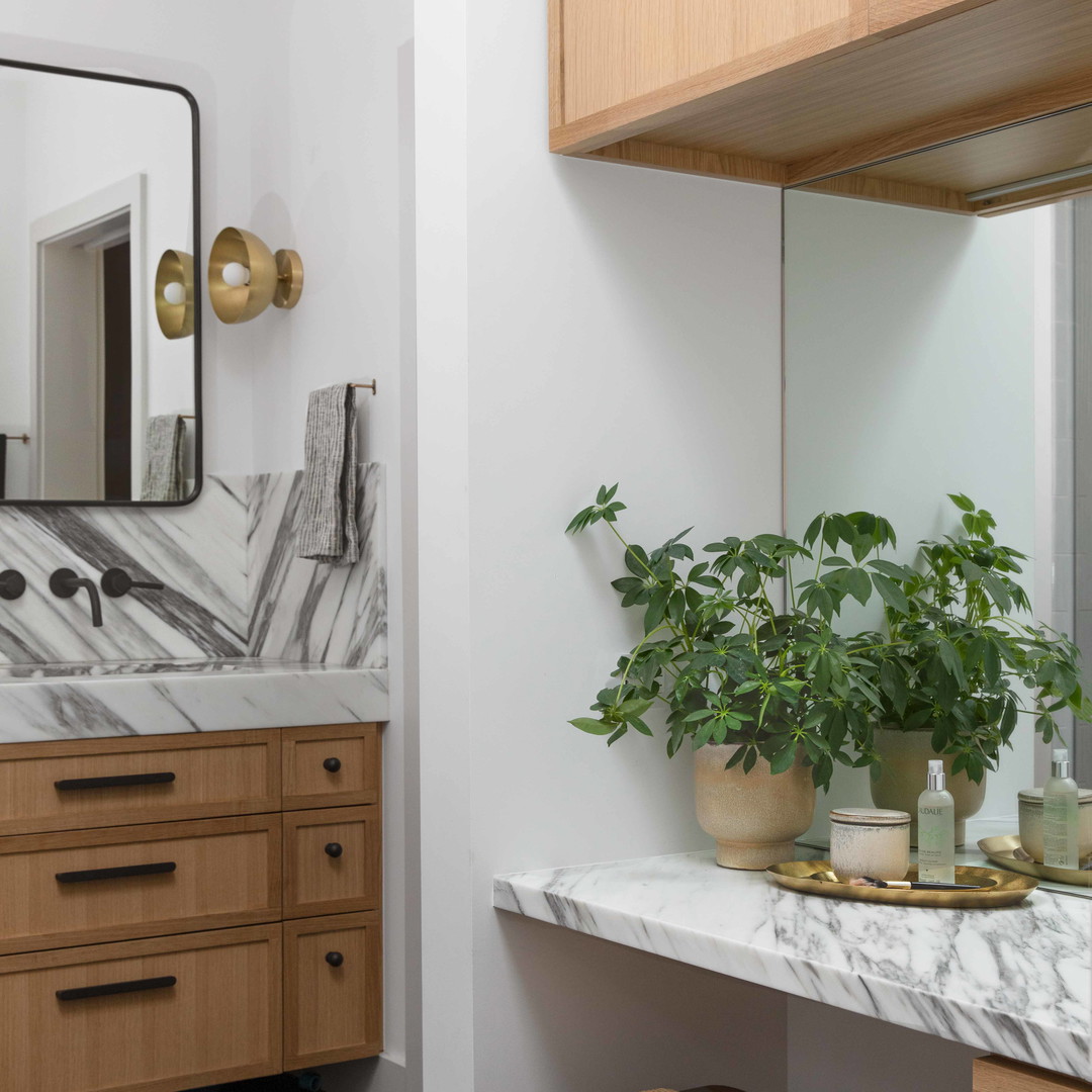 a bathroom with a marble counter top and wooden cabinets