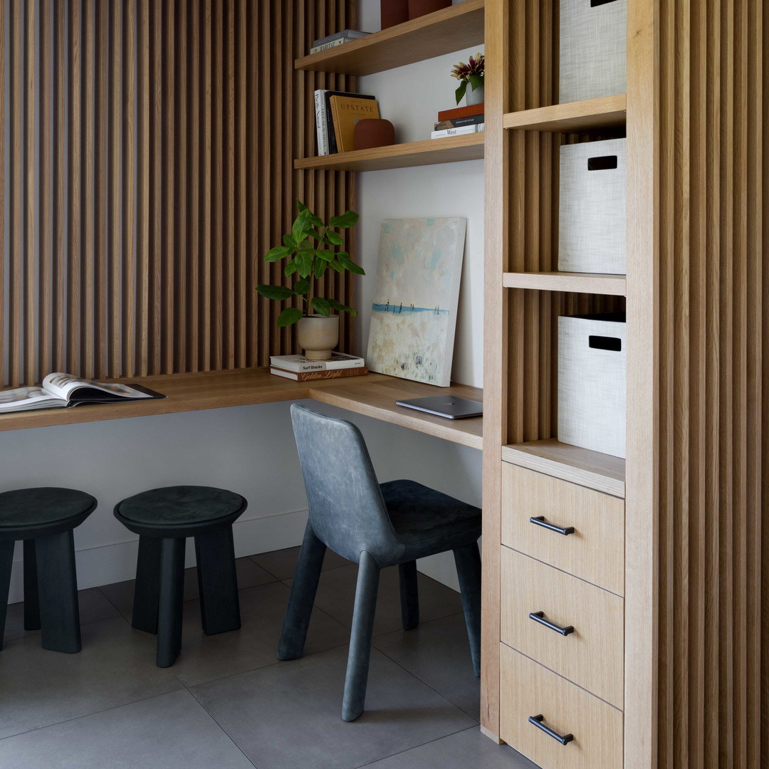 a home office with a desk and shelves