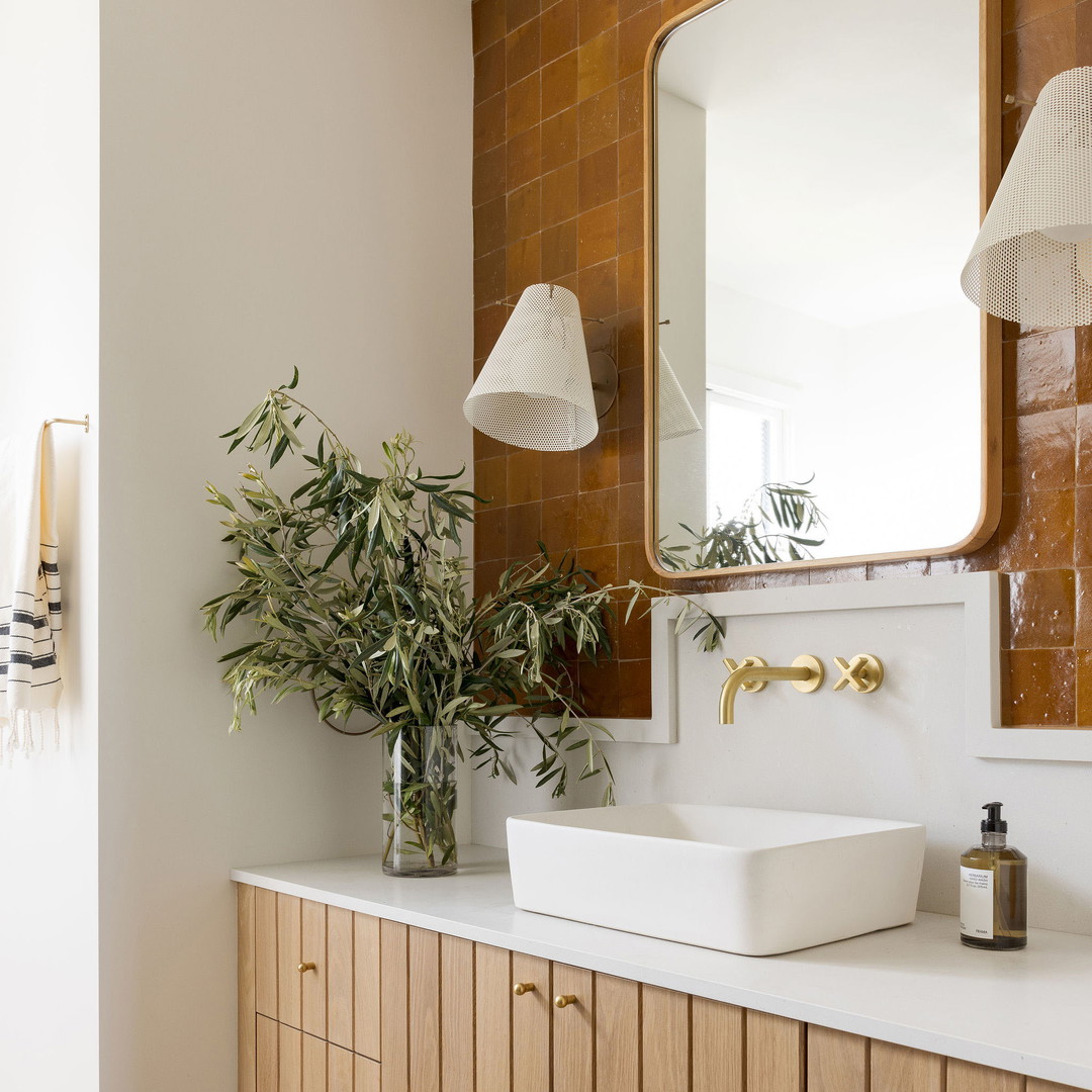 a bathroom with a sink, mirror, and stool