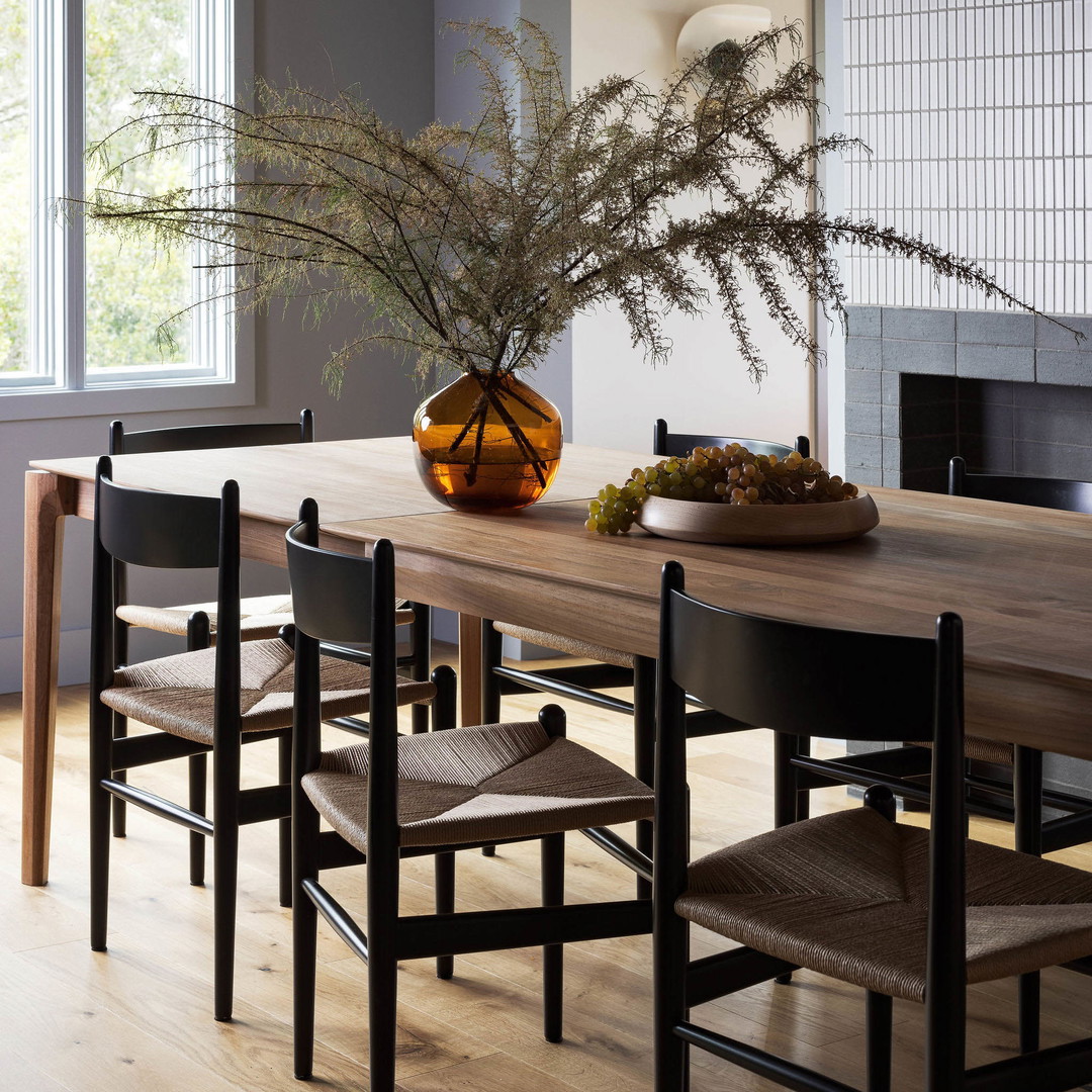 a dining room table with a vase of flowers on it