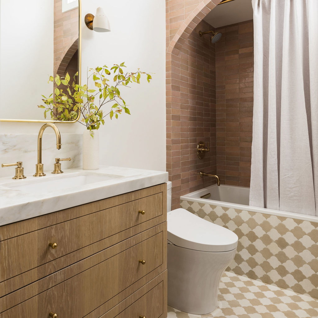 a white toilet sitting next to a bath tub in a bathroom