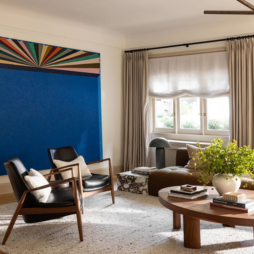 a living room filled with furniture and a painting on the wall