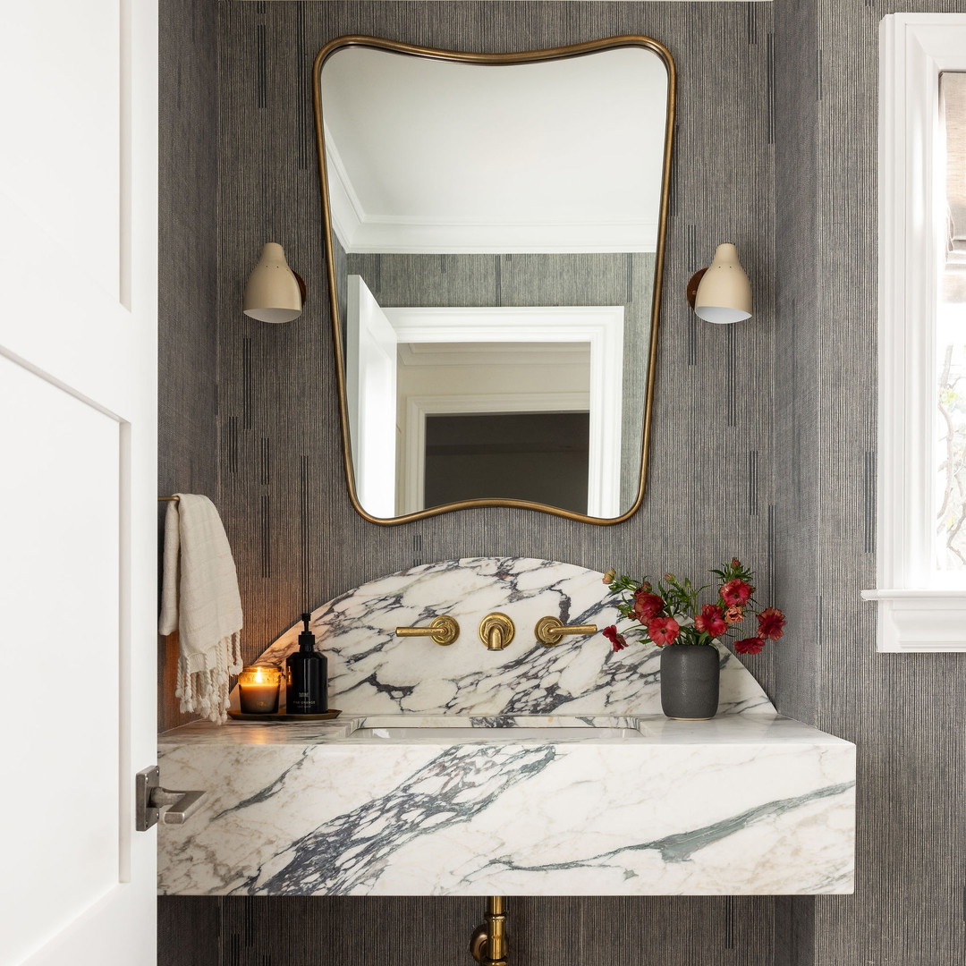 a bathroom with a marble sink and a large mirror